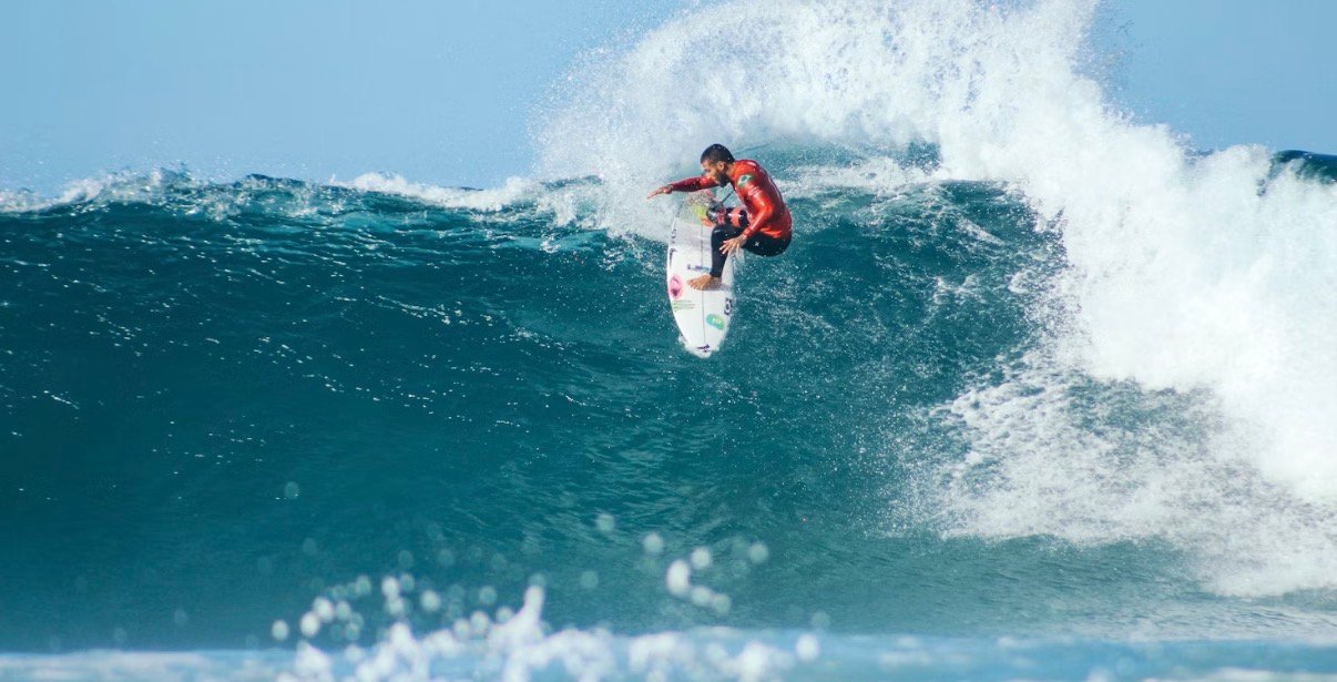 Surfer dropping in on steep wave face